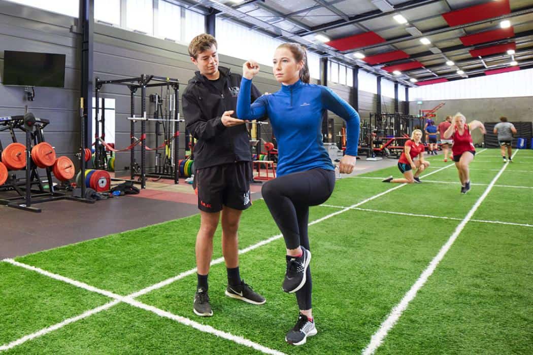 Coach assessing an athlete during performance training